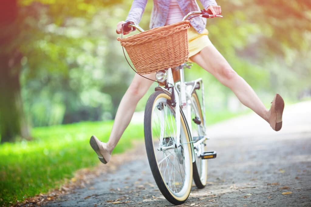 אישה רוכבת על אופניים עם סל.
